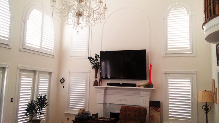 Boise great room with wall-mounted TV and arched windows.